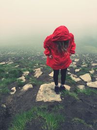 Rear view of woman standing in front of red umbrella