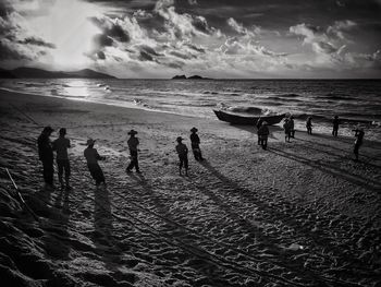 Panoramic view of people on beach against sky