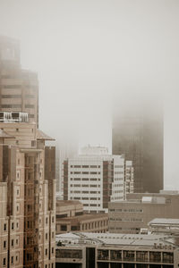 Buildings in city against sky during winter