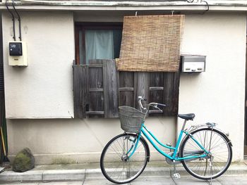 Bicycle parked against brick wall