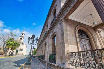 Street amidst buildings against sky in city