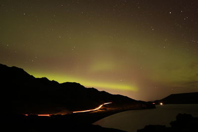 Scenic view of silhouette mountains against sky at night