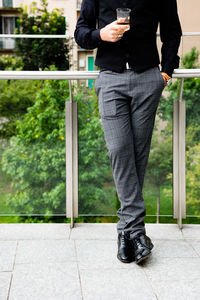Low section of man standing on mobile phone