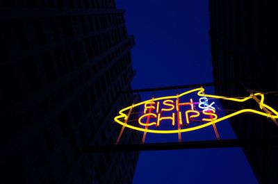 Low angle view of illuminated building against blue sky