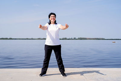 Full length of man standing in lake against sky