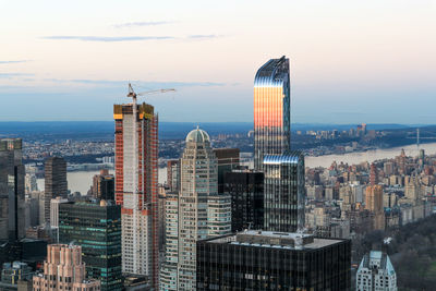 Skyscrapers in city against cloudy sky