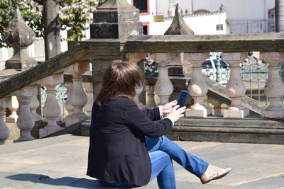 Woman using mobile phone at temple