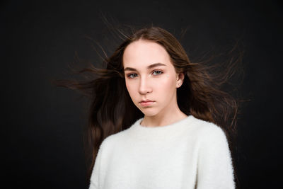 Portrait of a beautiful young woman over black background