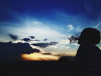 Rear view of silhouette man against sky during sunset