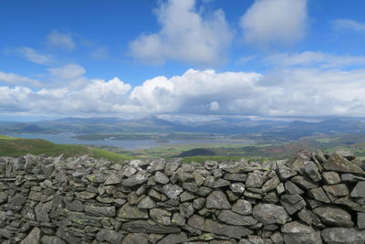 Stack of rocks on landscape against sky