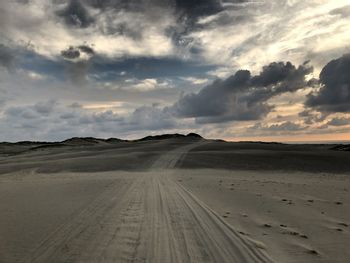 Scenic view of dirt road against sky