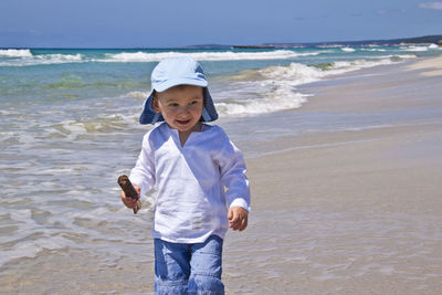 Boy standing on shore at beach