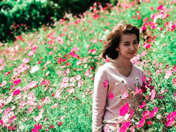 Young woman standing amidst flowers