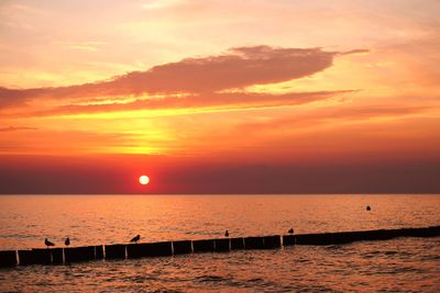 Scenic view of sea against romantic sky at sunset