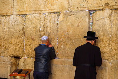 Rear view of man standing against wall