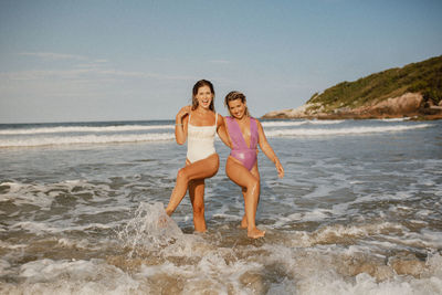 Full length of young woman standing at beach