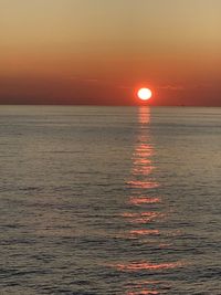 Scenic view of sea against orange sky