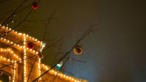 Low angle view of illuminated christmas lights against sky at night
