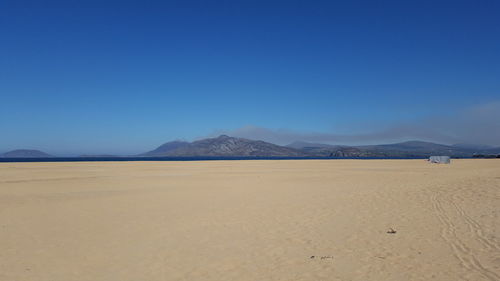 Scenic view of desert against clear blue sky