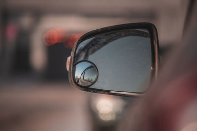 Close-up of eyeglasses on side-view mirror