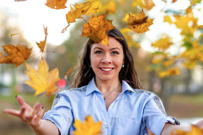 Portrait of smiling young woman against plants