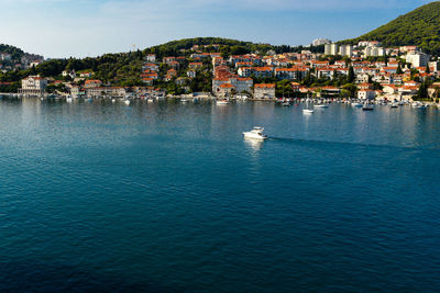 Scenic view of sea by town against sky