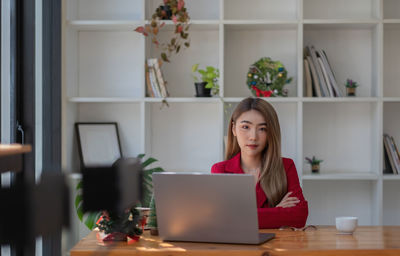 Young woman using laptop at table