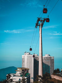 Low angle view of overhead cable car against buildings in genting highlands