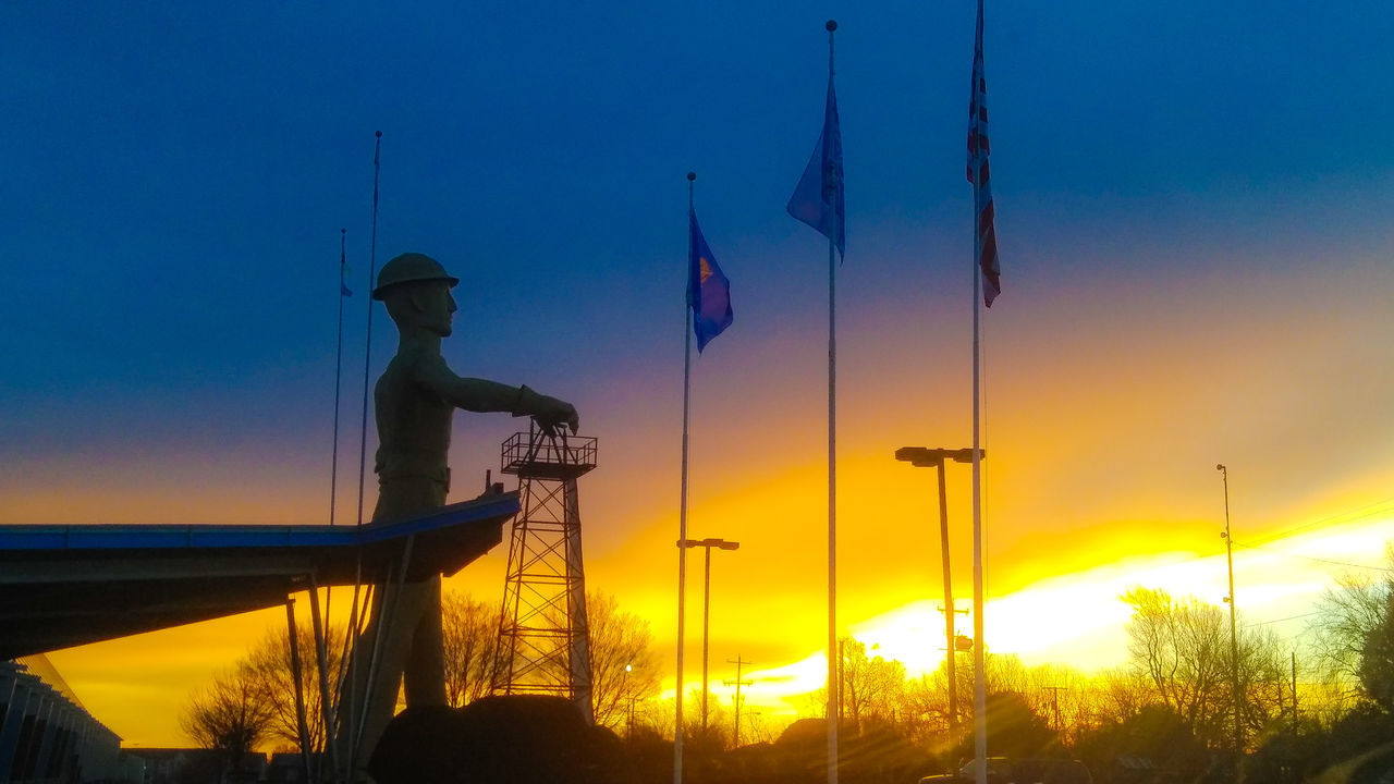 LOW ANGLE VIEW OF SILHOUETTE MAN AGAINST SKY AT SUNSET