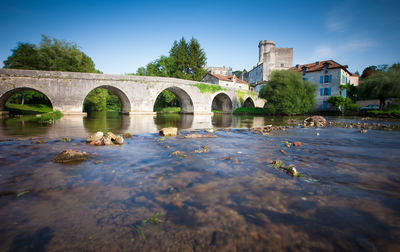 Arch bridge over river against sky
