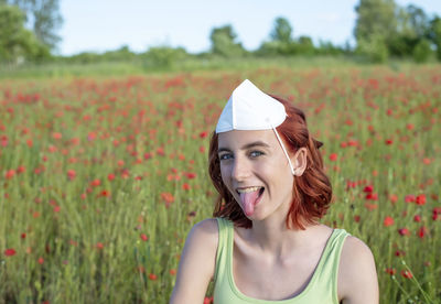 Portrait of young woman standing on field