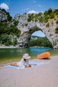 Woman sitting on shore at beach