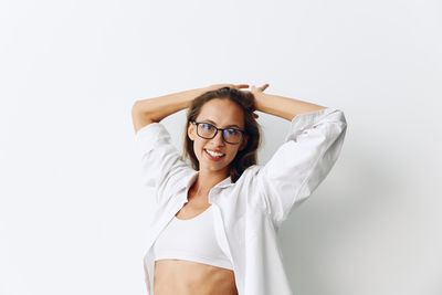 Young woman wearing sunglasses against white background