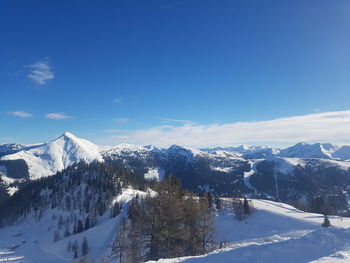 Scenic view of snowcapped mountains against blue sky