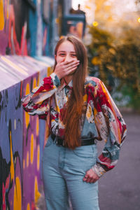 Portrait of young woman standing in city