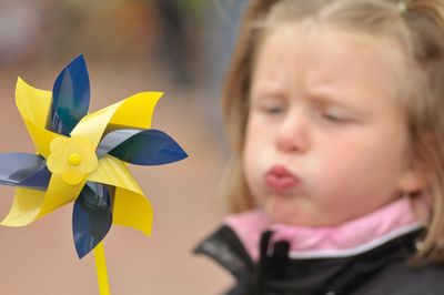 Close-up of girl blowing pinwheel toy