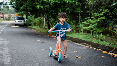 Full length portrait of boy standing on road