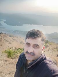 Portrait of young man with mountains in background