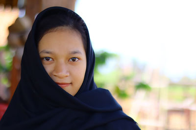 Close-up portrait of mid adult woman against blurred background