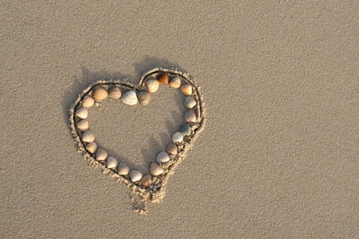 Close-up of heart shape on sand
