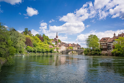 Arch bridge over river against buildings