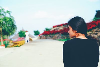 Rear view of woman standing on land against sky