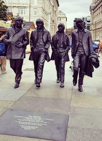 Men walking on zebra crossing in city