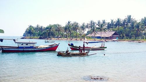 Boats moored on sea against clear sky