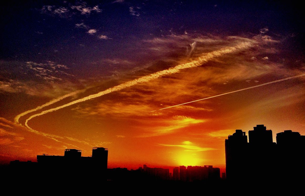 sunset, silhouette, building exterior, architecture, built structure, sky, city, orange color, scenics, beauty in nature, cloud - sky, dramatic sky, dark, nature, cityscape, cloud, outdoors, building, vapor trail, tranquil scene