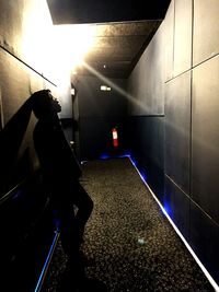 Man walking on staircase in illuminated building