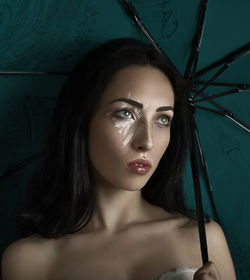 Close-up of young woman holding umbrella