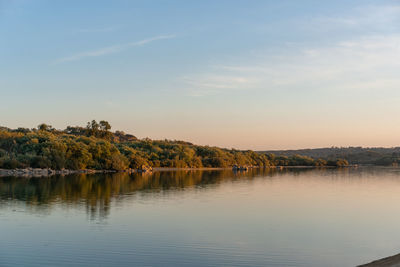 Scenic view of lake against sky at sunset