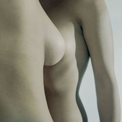 Close-up of naked woman against gray background