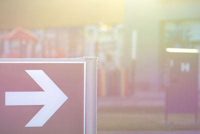 Close-up of arrow sign on glass